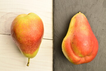 Sweet juicy pears with a serving plate of slate on a white wooden table.