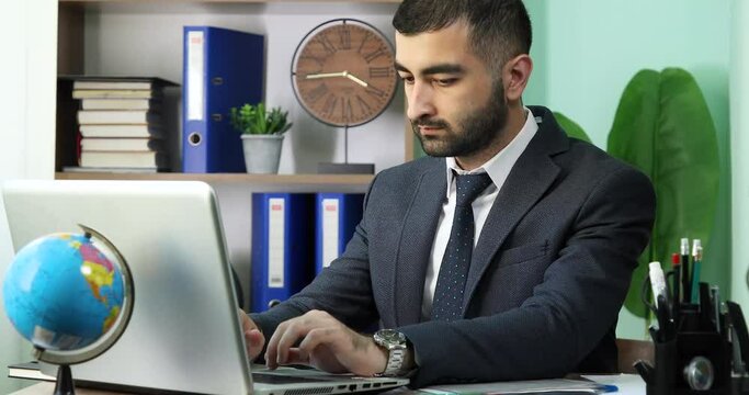Young businessman working on a laptop at a modern office