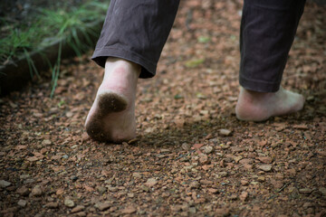 Closeup of dirty barefoot of woman walking in the nature