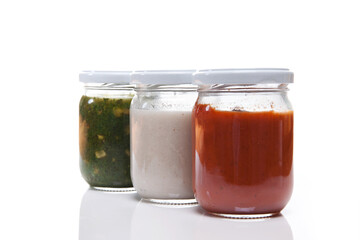 Nutrition concept - Healthy food, Diet, Detox, Clean Eating or Vegetarian concept. Glass jars of nutritious food against white background. Delicious soups in glass jars. 