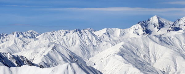 Naklejka premium Panoramic view on high snowy mountains and blue sky with clouds
