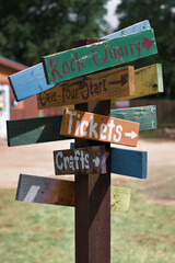 Wood sign arrow paths to activities and ticket booth for cave rock quarry concessions and other fun things for familes to do on weekend vacation.