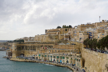 VALLETTA, MALTA - DEC 31st, 2019: Panoramic skyline view of the Grand Harbor of Valletta and Upper Barrakka Gardens at daylight with blue sky during winter