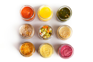 Nutrition concept - Healthy food, Diet, Detox, Clean Eating or Vegetarian concept. A set of nutritious food on small glass jars against white background. Set of delicious food in glass jars. Top view