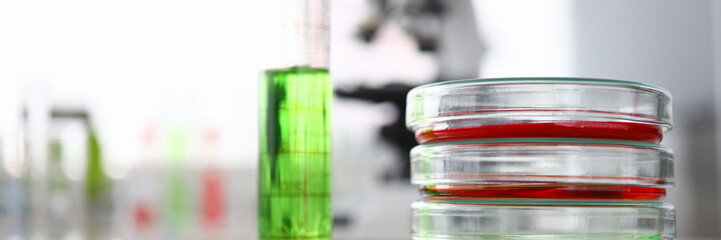 Close-up of laboratory glass containers and flask with colored liquid. Researching biotechnology and pharmacy industry for human. Chemical experiments concept