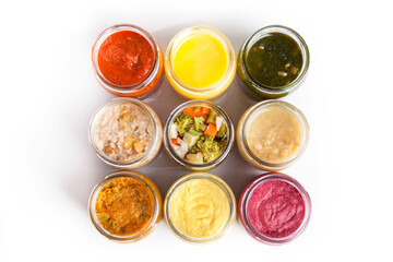Nutrition concept - Healthy food, Diet, Detox, Clean Eating or Vegetarian concept. A set of nutritious food on small glass jars against white background. Set of delicious food in glass jars. Top view