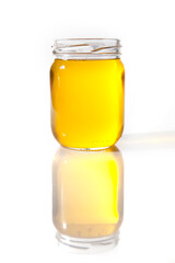 Glass jar with melted ghee butter over white background. Nutrition concept - Healthy food, Diet, Detox, Clean Eating or Vegetarian concept.