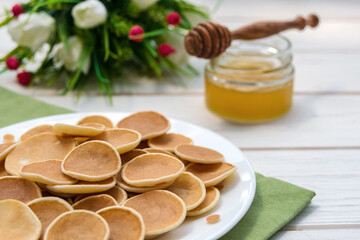 Mini pancake cereal. American magnificent pancakes on a white plate. Tasty breakfast.