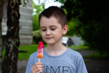 a boy eats Popsicles on a stick. on the street. summer