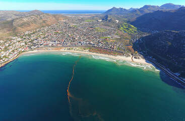 Cape Town, Western Cape / South Africa - 06/06/2018: Aerial photo of red tide at Fish Hoek Beach with Noordhoek in the background