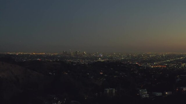 AERIAL: Over Hollywood Hills at Night with view on Downtown Los Angeles view, 