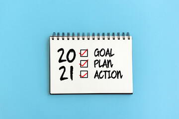 2021 goal, plan, action checklist text text on note pad blue background