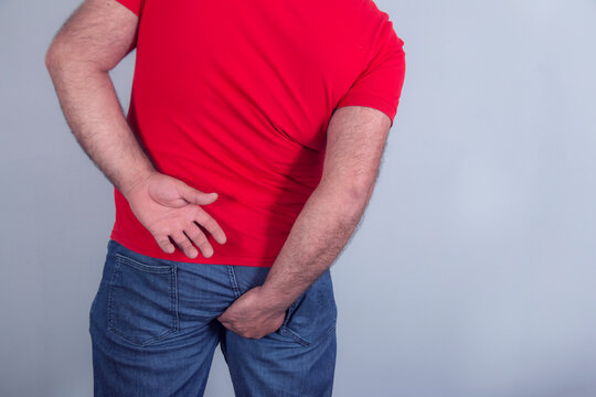 Man holding his bottom in pain isolated in grey
