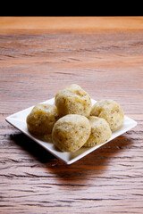 Healthy homemade cheese buns with chia, rustic style, on a white plate over wooden background.