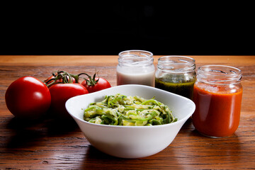 Nutrition concept - Healthy food, Diet, Detox, Clean Eating or Vegetarian concept. Healthy pasta with sauce, basil, fresh tomatoes over rustic wooden background