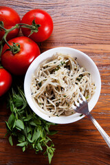 Nutrition concept - Healthy food, Diet, Detox, Clean Eating or Vegetarian concept. Healthy pasta with sauce, basil, fresh tomatoes over rustic wooden background