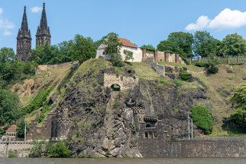 Fototapeta na wymiar flowing river Vltava under the old fortress Vyšehrad and the Basilica of St. Peter and Paul in Prague. There is a tunnel under the fortress. in the summer in the center 