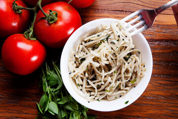 Nutrition concept - Healthy food, Diet, Detox, Clean Eating or Vegetarian concept. Healthy pasta with sauce, basil, fresh tomatoes over rustic wooden background