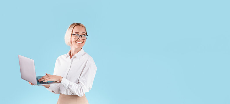 Positive businesswoman with laptop computer looking at empty space for your design, blue background