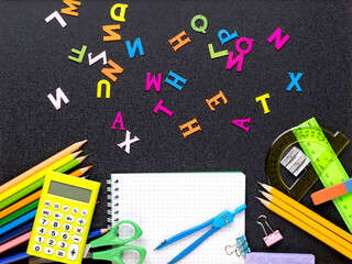 Many different school supplies on blackboard copy space background. Back to school concept.