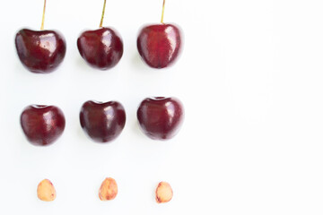 Ripe cherries berries bunch and pits on a white background. Isolate. Copy space