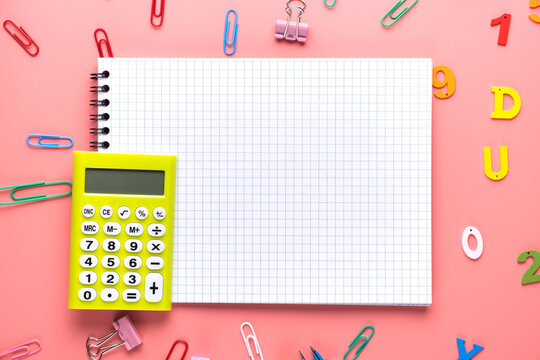 School supplies and empty notepad white sheet of paper with yellow calculator on copy space background.