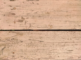 old wooden boards with beige peeling paint with cracks. rough surface texture. Close