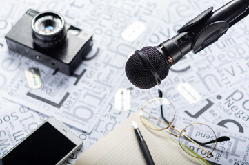 Stationery items on the table. Microphone, voice recorder and notebook. Shallow depth of field.