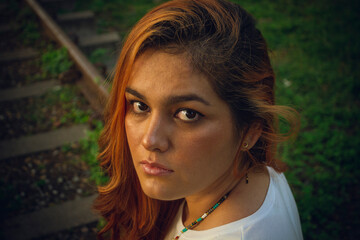 Photograph of young woman with red hair sitting in a park