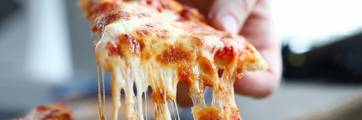 Male arm taking slice of cheesy tasty fresh pizza