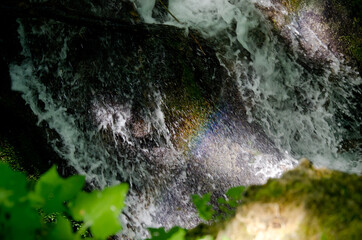 abstract image of falling water in nature with foam and splash and sun illumination