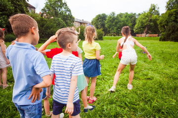 Fototapeta premium The group of friends are actively relaxing in a summer park