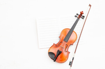 Fototapeta na wymiar Close up of violin with bow and music book on white background