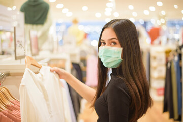 woman with face mask is shopping clothes in Shopping center