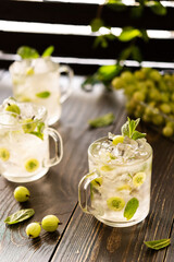 Cold summer drink with green gooseberries and mint, lemonade with ice
