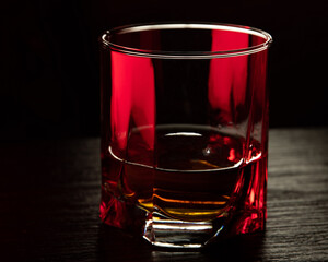 Cognac glass in ruby light with white, amber highlights.