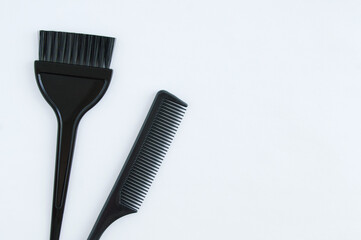 Hairdressing tools. Plastic black comb and brush for coloring hair on white background.