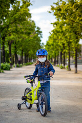 Girl wearing a mask with her bicycle 