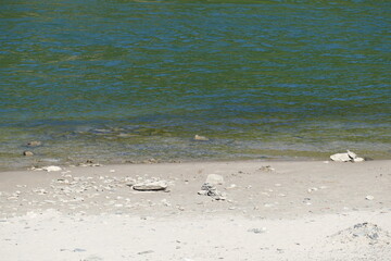 Strand und Flusswasser mit ein paar Steinen