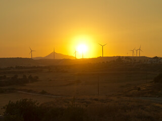 Fototapeta na wymiar Rural landscape with wind turbines at sunset