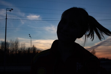 Black female silhouette at sunset in frontal profile. Silhouettes of people at sunset.