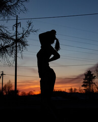 Black female silhouette at sunset in a side profile. Silhouettes of people at sunset.