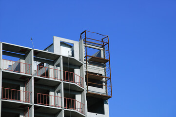 Construction of a multi-storey building close-up in residential quarter during the day.