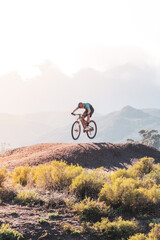 mountain biker jumping off of a dirt mount