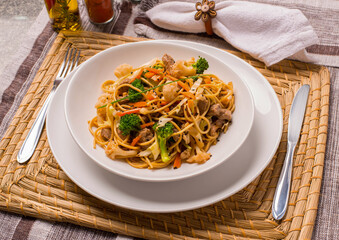 Delicioso yakisoba servido em um prato branco.