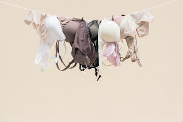 Female bra and panties is hanging on the rope isolated on a light background.