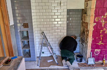 Fototapeta premium Man is filling the gaps between tiles