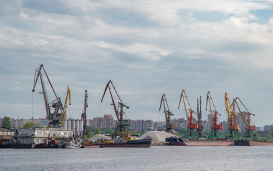Shipbuilding plant. Crane operation at the shipbuilding, commercial, sea, river, port. Loading, unloading of goods, bulk materials by cranes of the river port (dock).