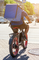 Male courier delivers food on a bicycle.