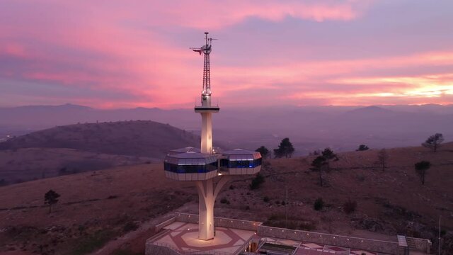 Podgorica Montenegro at sunset: pink and blue sky over Dajbabe hill (Dajbabska Gora) featuring illuminated radio frequency spectrum control tower.